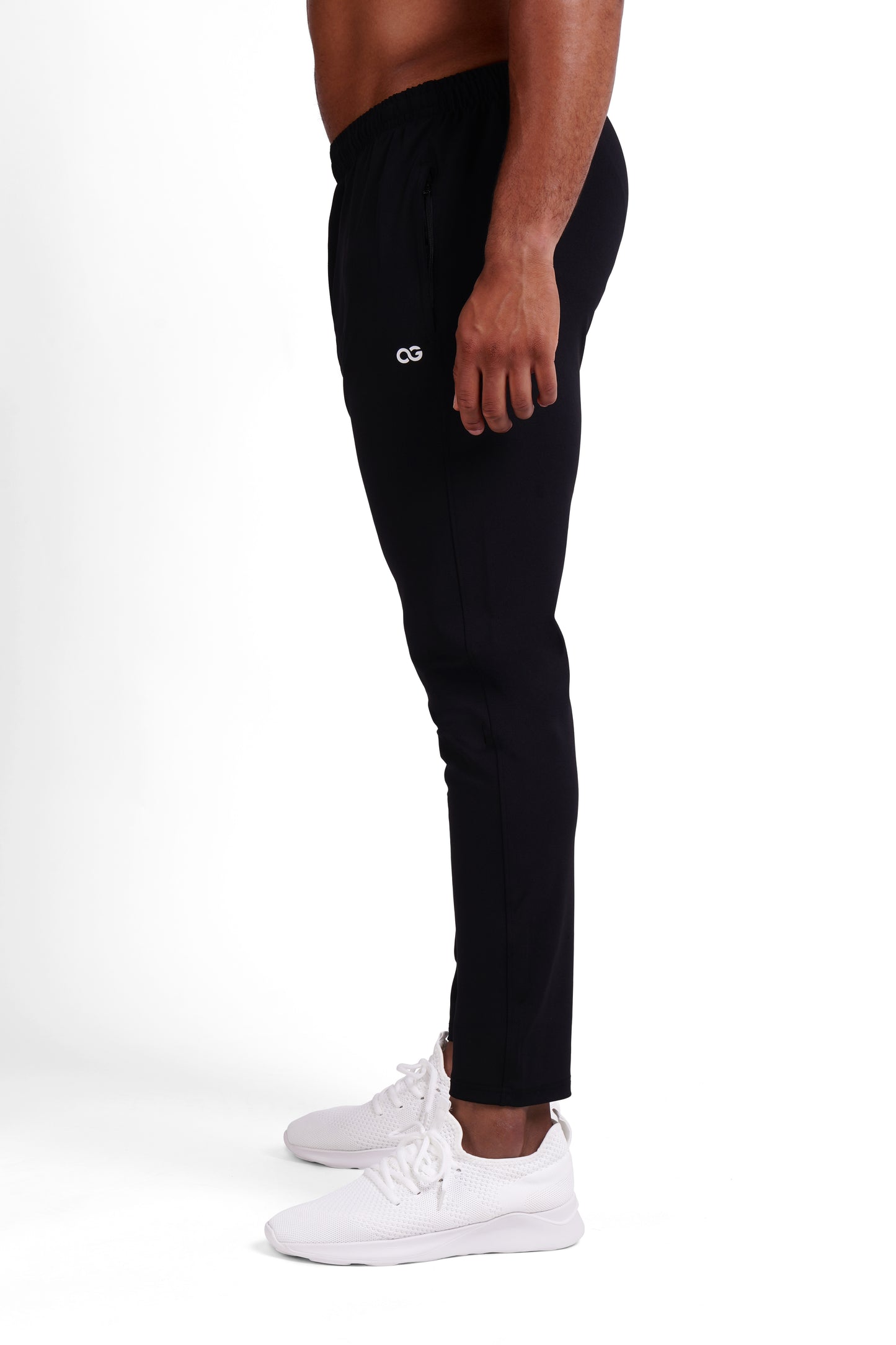 Side view of black OG training pants showing the white OG logo on the thigh and tapered leg