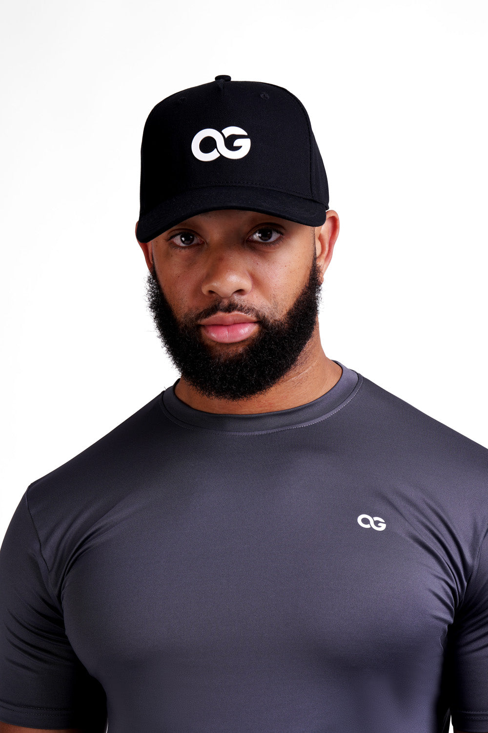 Man wearing a white OG cap and dark grey training tee, looking straight at the camera