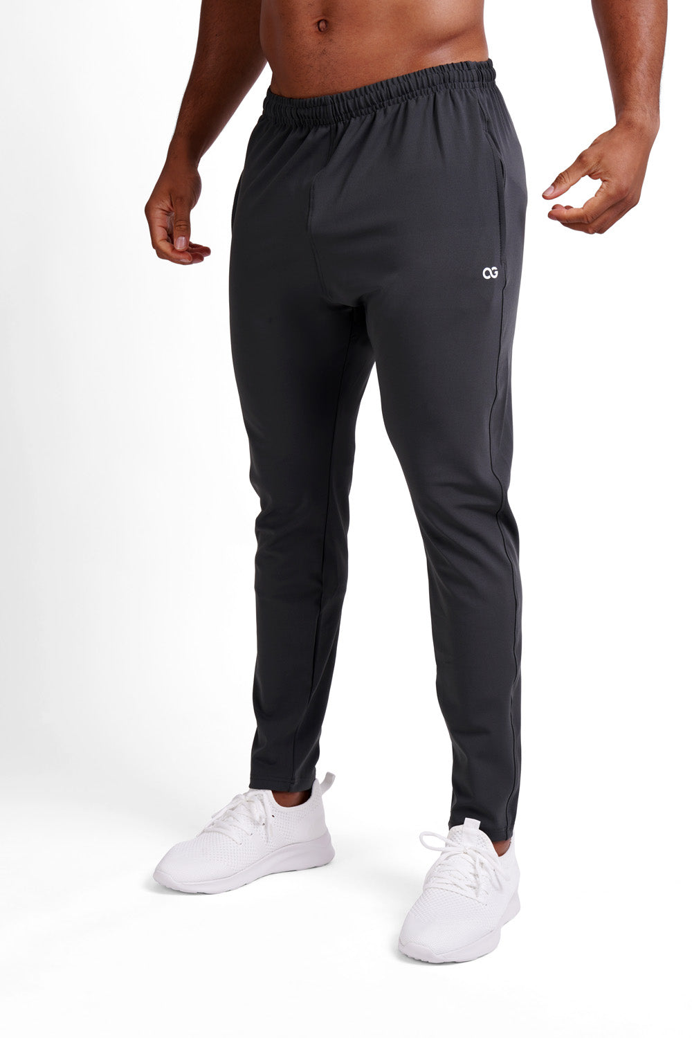Man wearing Silver Grey OG training pants at an angle, white OG logo on thigh, elastic waistband